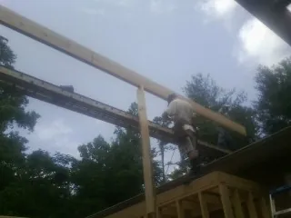 Carpenter setting a ridge beam over a new addition frame — Ice Dam Removal by Roofing Brothers in Fortville