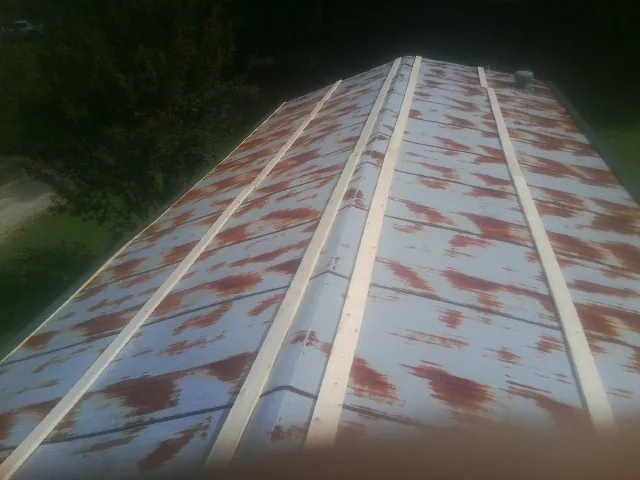 Rusted metal roof panels with new wood purlins before replacement — Storm Damage Roof Repair in Fortville by Roofing Brothers