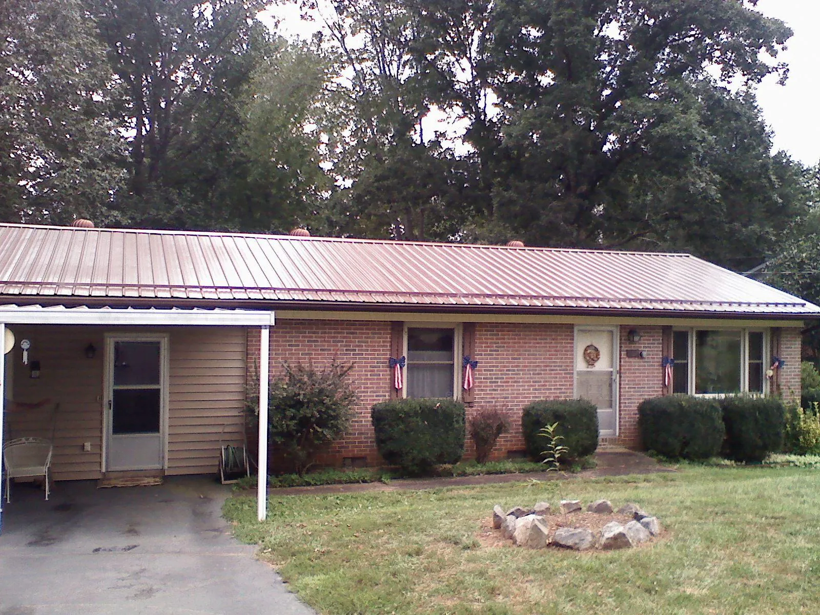Bronze metal roof and carport on a brick ranch home — Roof Repair work by our crew in Fortville